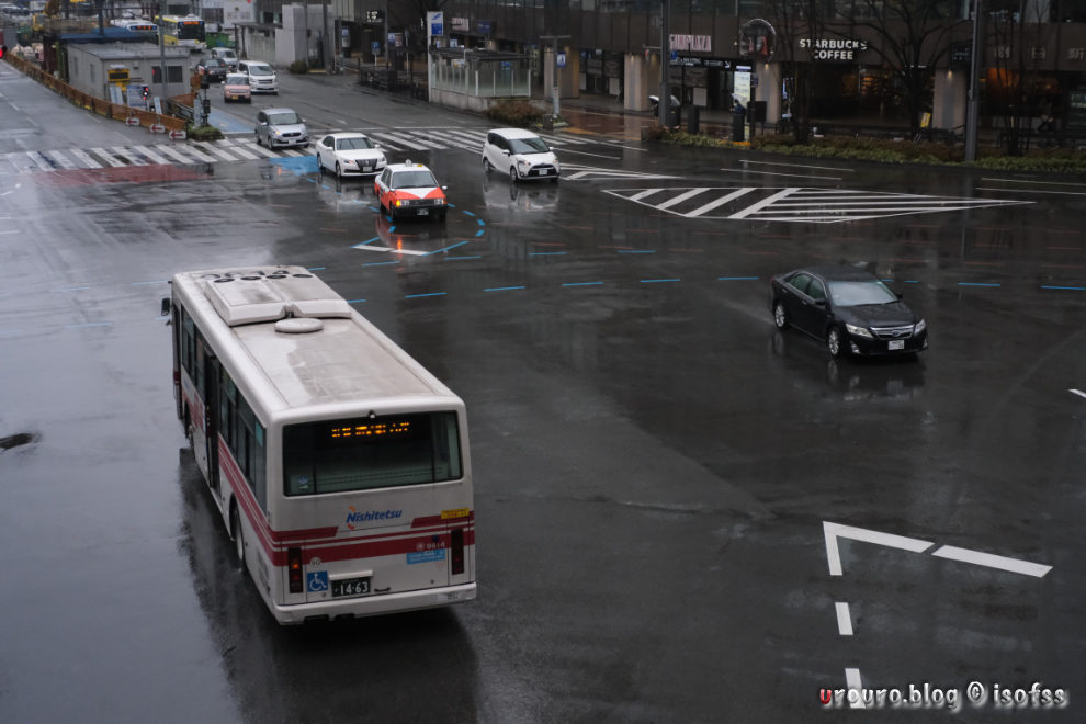 雨の博多駅、車が行き交う。
