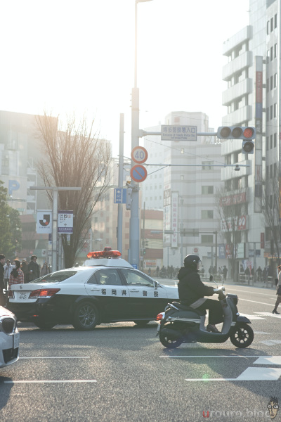 朝の通勤ラッシュにパトカーが写っている。ファントムレンズの絞り羽はハート。