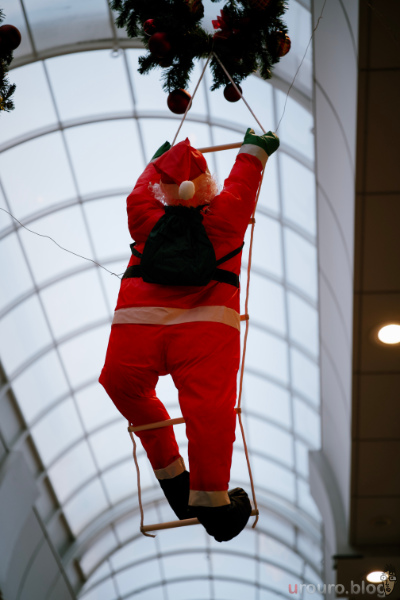 商店街の中で煙突に登るサンタクロースの人形。NIKKOR Z 24-70mm f/2.8 S IIで撮影したスナップ作例。